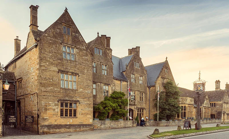  A row of old stone buildings stands alongside a road, showcasing historic architecture and weathered facades.